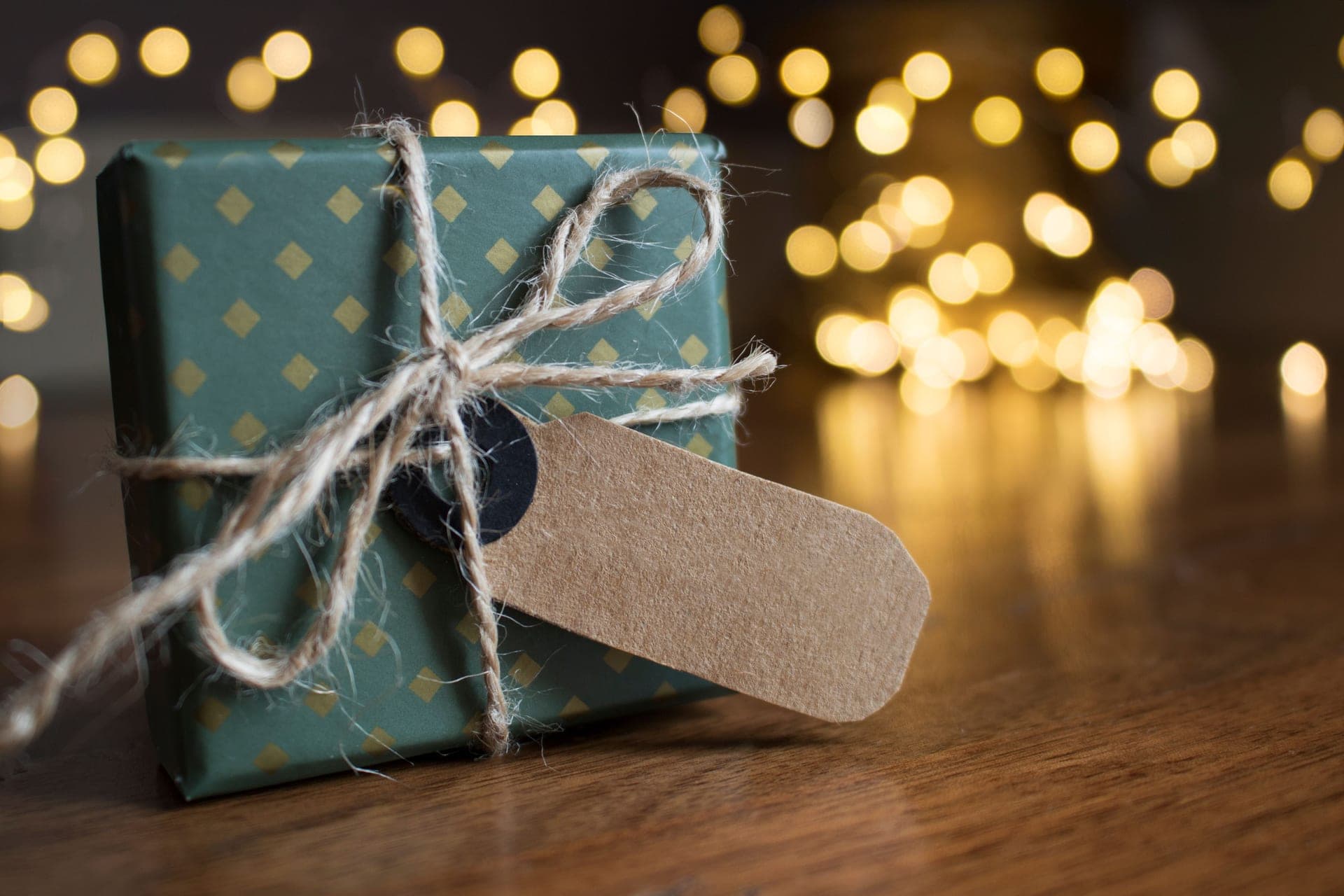 A gift wrapped in brown paper and tied with twine, resting on a table